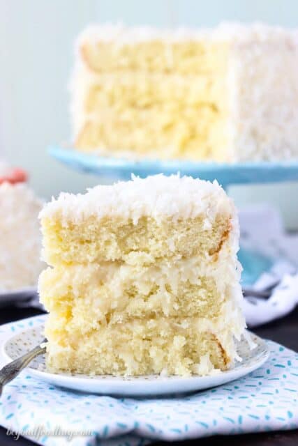 This Coconut Custard Cake is layers of coconut cake, with a coconut custard filling and finished with a cream cheese icing. This from scratch recipe will be one you make over and over again.