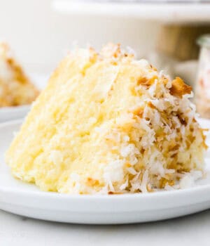 A slice of coconut custard cake on a white plate.