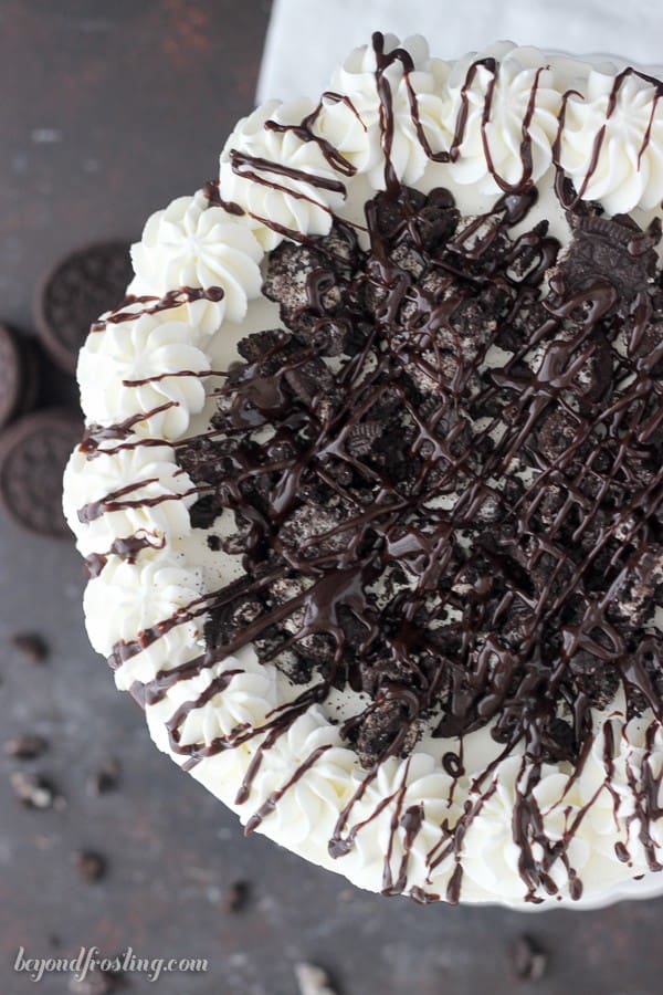 Oreo icebox cake with whipped cream, crushed cookies and fudge drizzle.