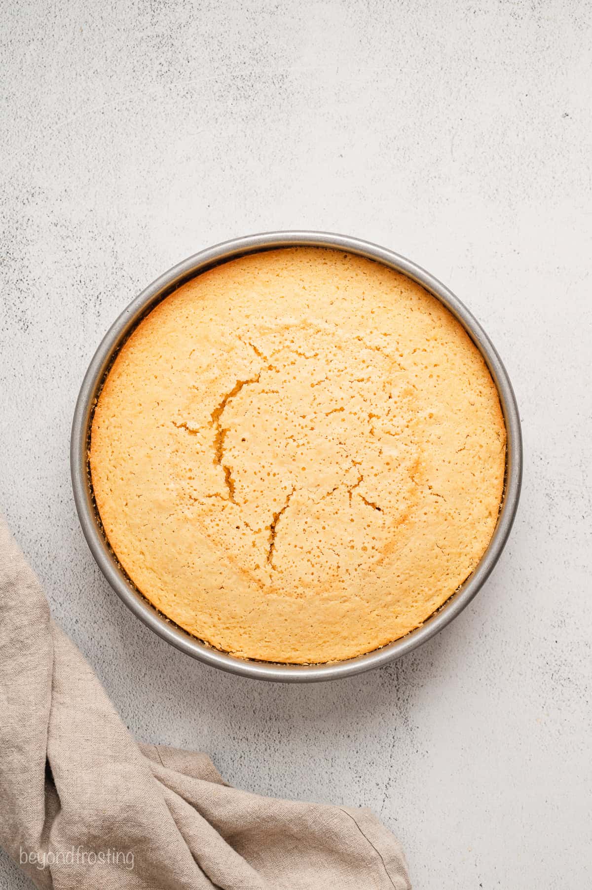 Baked lemon olive oil cake in a round cake pan.