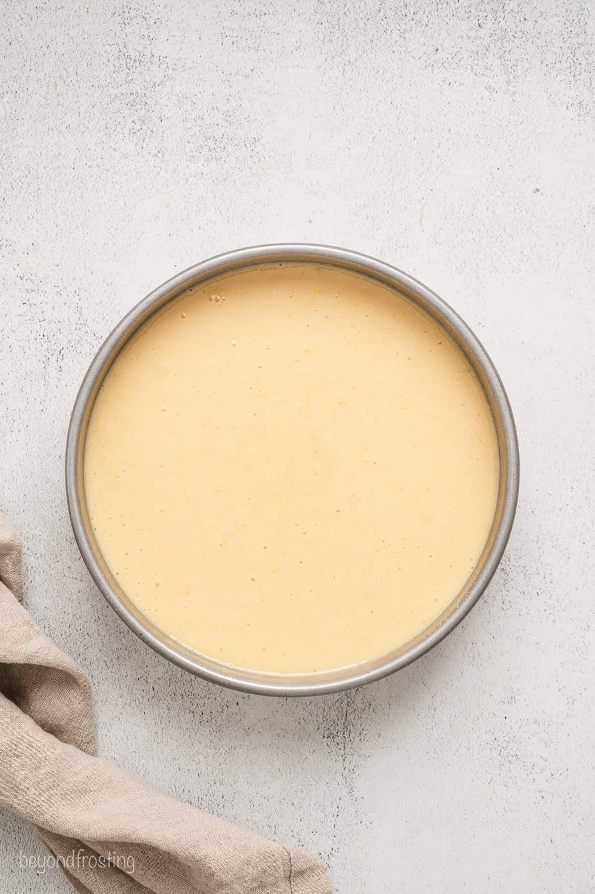 Lemon cake batter in a round cake pan.