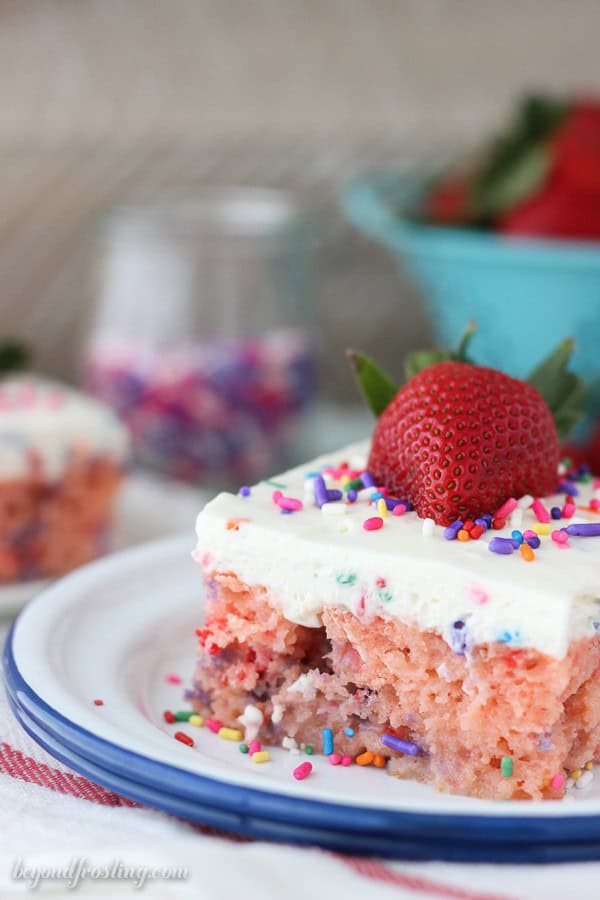 A slice of strawberry poke cake on a plate
