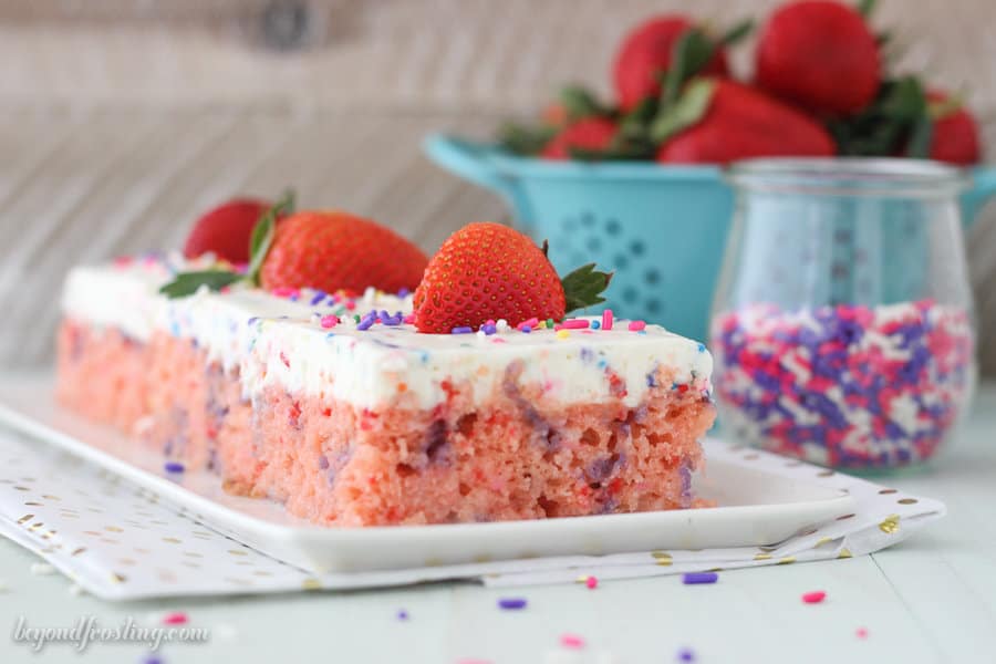Two slices of strawberry poke cake on a plate