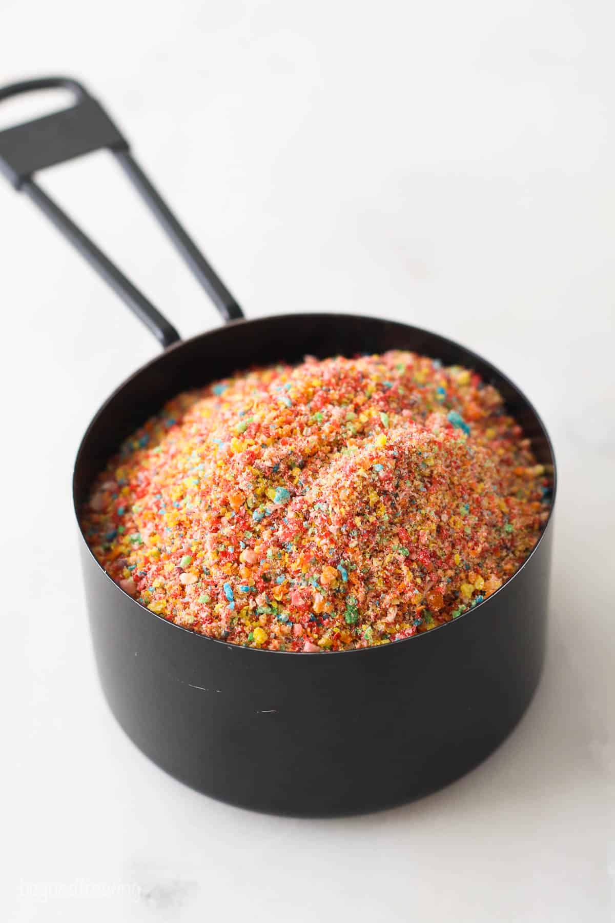 Fruity pebbles crumbs in a measuring cup