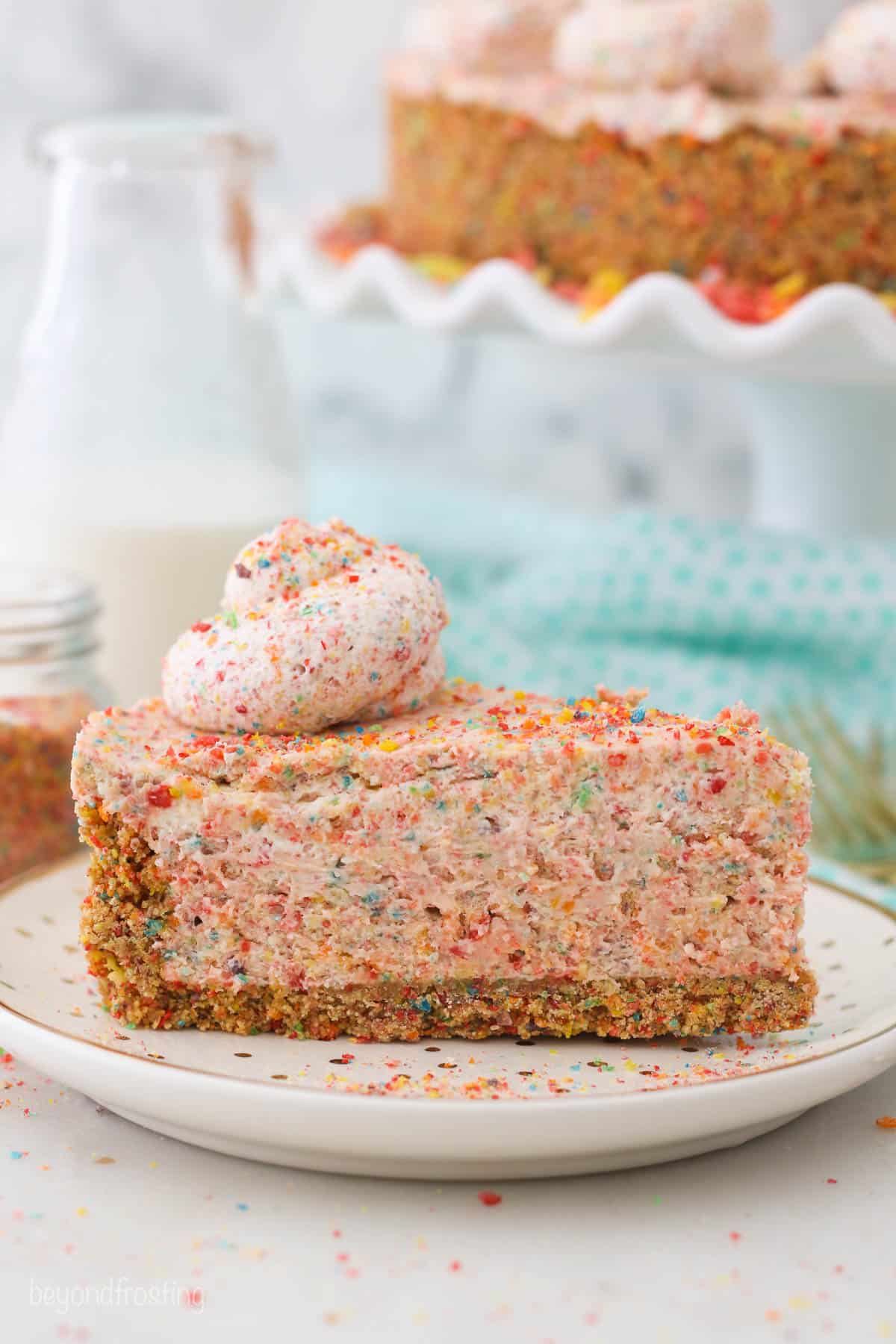 A slice of fruity pebbles cheesecake on a white plate