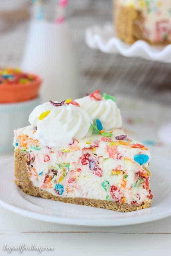 A Piece of No-Bake Fruity Pebbles Cheesecake on a White Plate