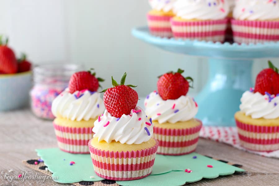 Quick and easy Strawberry and Cream Cupcakes. The vanilla cupcakes are sweetened with strawberries, a vanilla mousse and a whipped cream topping.