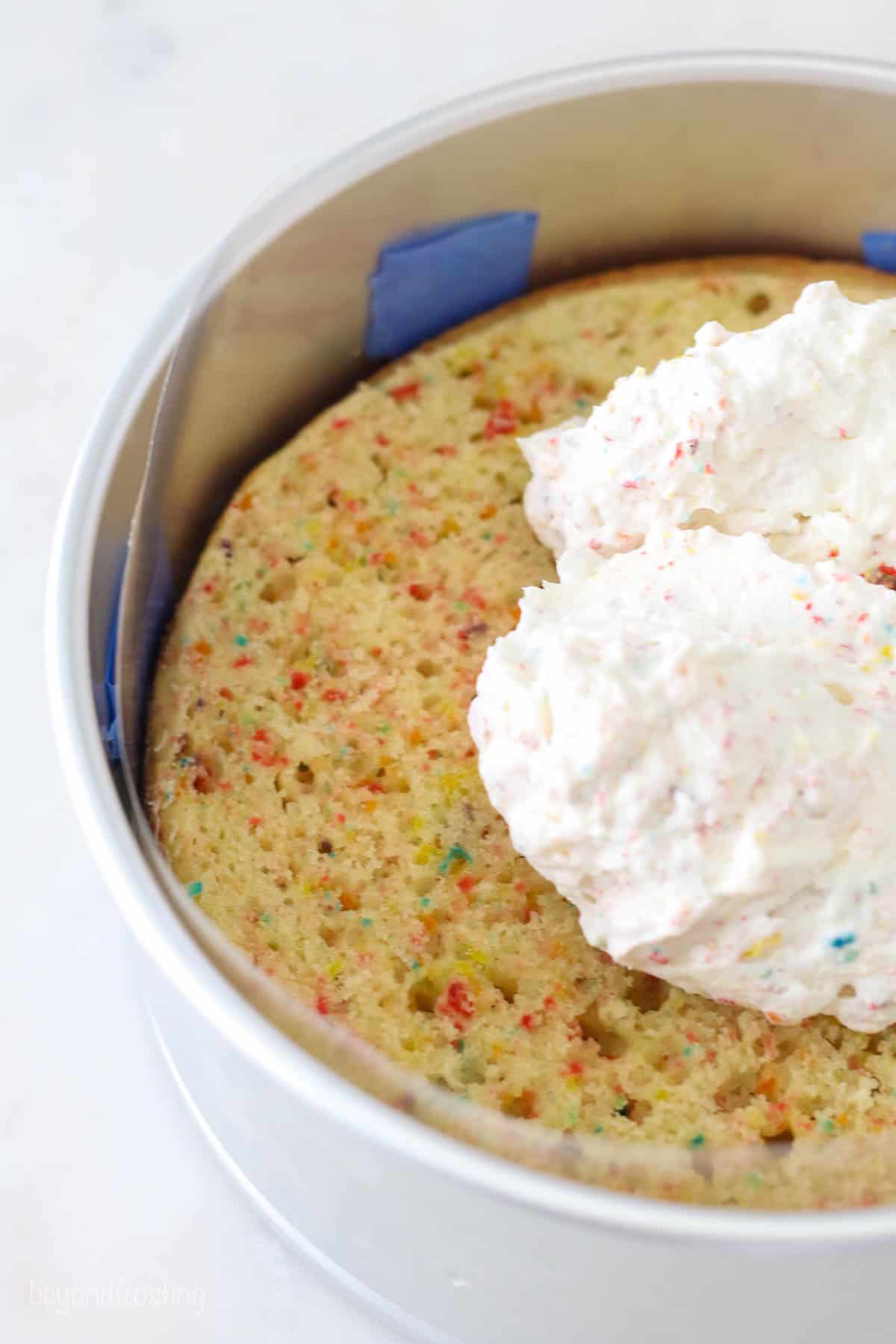 Fruity pebble ice cream beings spread on a cake