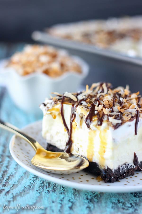 This No-Bake Samoa lush is an icebox cake featuring an Oreo cookie crust, a layer of caramel cheesecake, coconut mousse and a whipped cream topped with caramel, hot fudge and toasted coconut