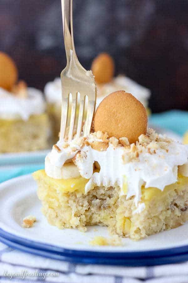 This Easy Banana Pudding Poke Cake is outrageously amazing. It is a doctored cake mix with banana, brown sugar and buttermilk filled with vanilla pudding and topped with fresh sliced bananas, whipped cream and crushed vanilla wafer cookies.