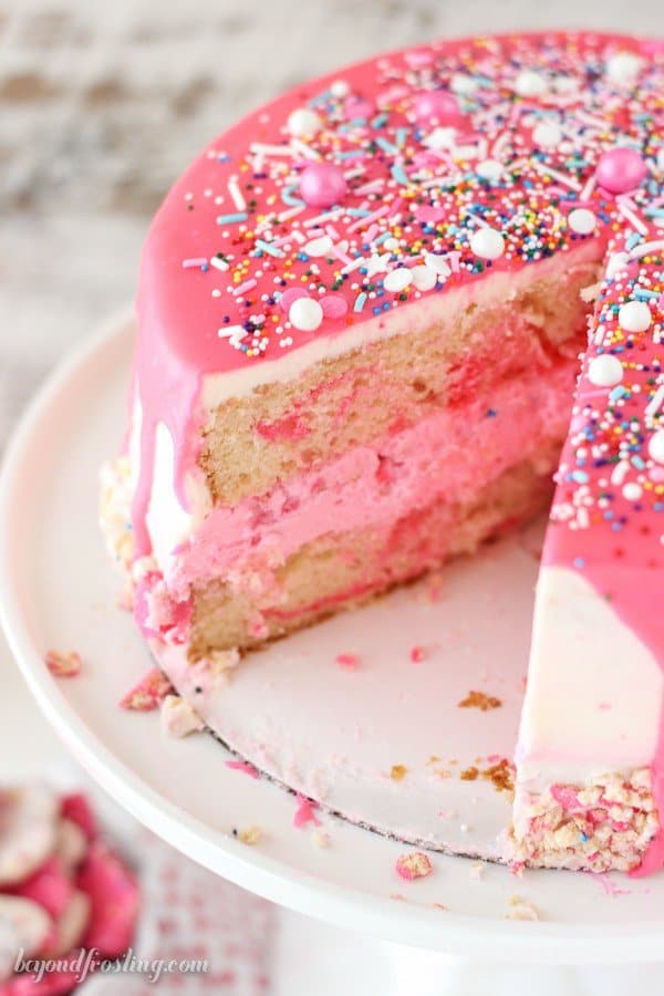 How fun is this Circus Animal Cookie Cake? This cake is layers of vanilla cake, vanilla frosting and Circus Animal Cookies with a pink chocolate ganache. There’s a lot of pink and definitely some sprinkles.