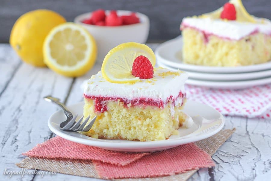 A horizontal shot of alice of lemon cake with raspberry filling and a fruit garnish