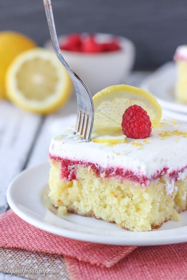 A silver fork sinking into a slice of lemon cake