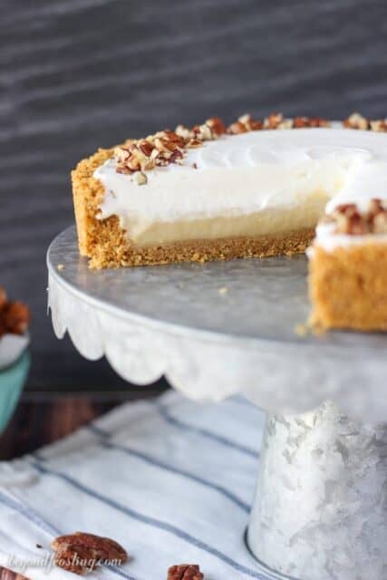 A no-bake butterscotch pudding pie with a slice cut out on a metal cake plate