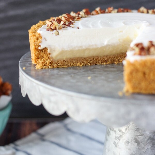 A No-Bake Bourbon Butterscotch Pie on a Silver Cake Stand