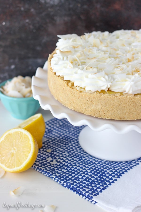 A No-Bake Lemon Macaroon Cheesecake on a white cake plate