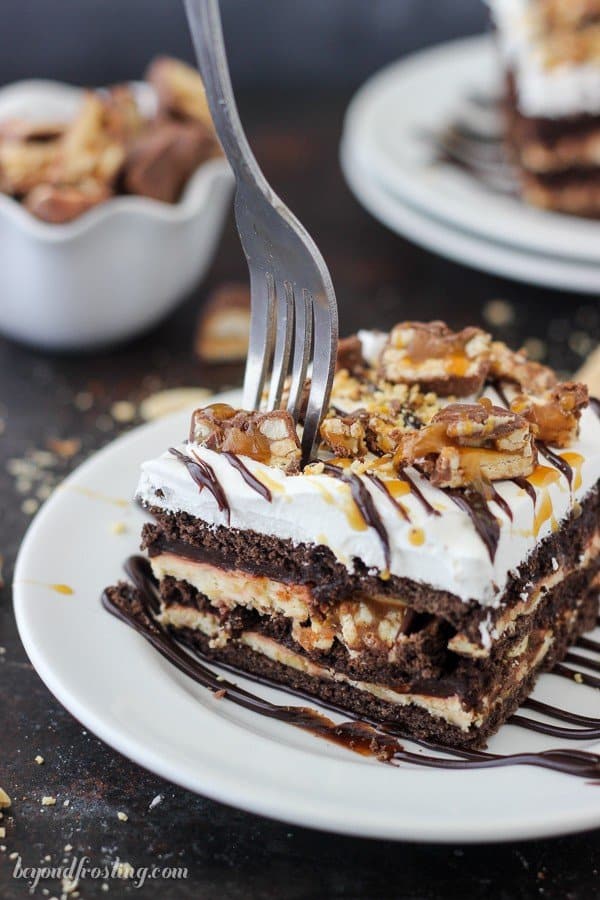 Snicker fans rejoice. This No-Bake Snickers Icebox Cake is the perfect way to cool down this summer. This dessert has layers of chocolate graham crackers, caramel cream cheese, chocolate pudding, Snickers bars and salty peanuts.