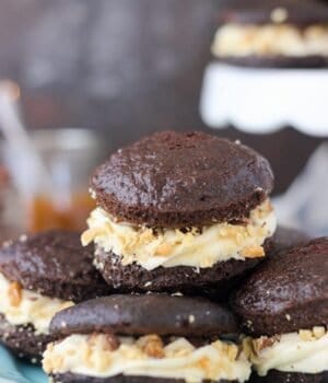 Sinful Snickers Whoopie Pies: a delicate chocolate cake with caramel buttercream, salty peanuts and snickers bars.
