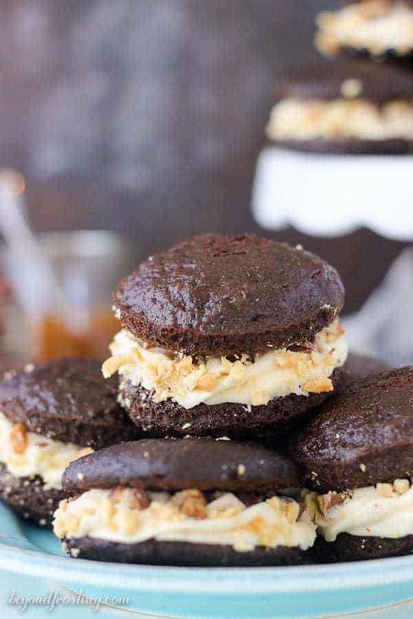 Sinful Snickers Whoopie Pies: a delicate chocolate cake with caramel buttercream, salty peanuts and snickers bars.