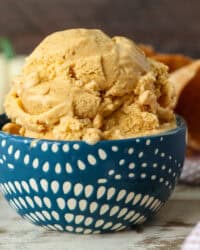 Side view of a scoop of pumpkin pie ice cream in a blue and white patterned bowl.