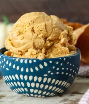 Side view of a scoop of pumpkin pie ice cream in a blue and white patterned bowl.