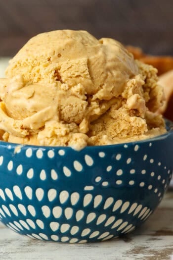 Side view of a scoop of pumpkin pie ice cream in a blue and white patterned bowl.