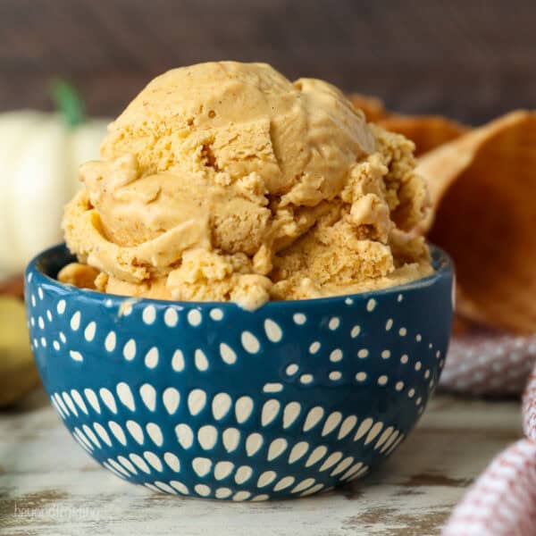 Side view of a scoop of pumpkin pie ice cream in a blue and white patterned bowl.