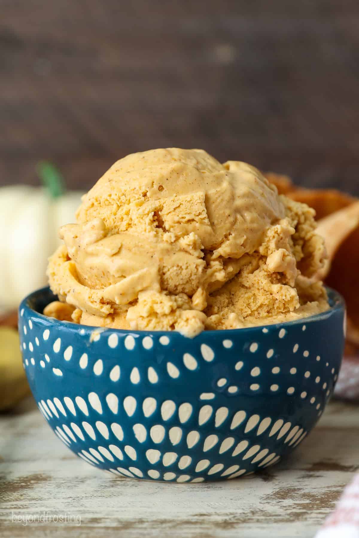 Side view of a scoop of pumpkin pie ice cream in a blue and white patterned bowl.