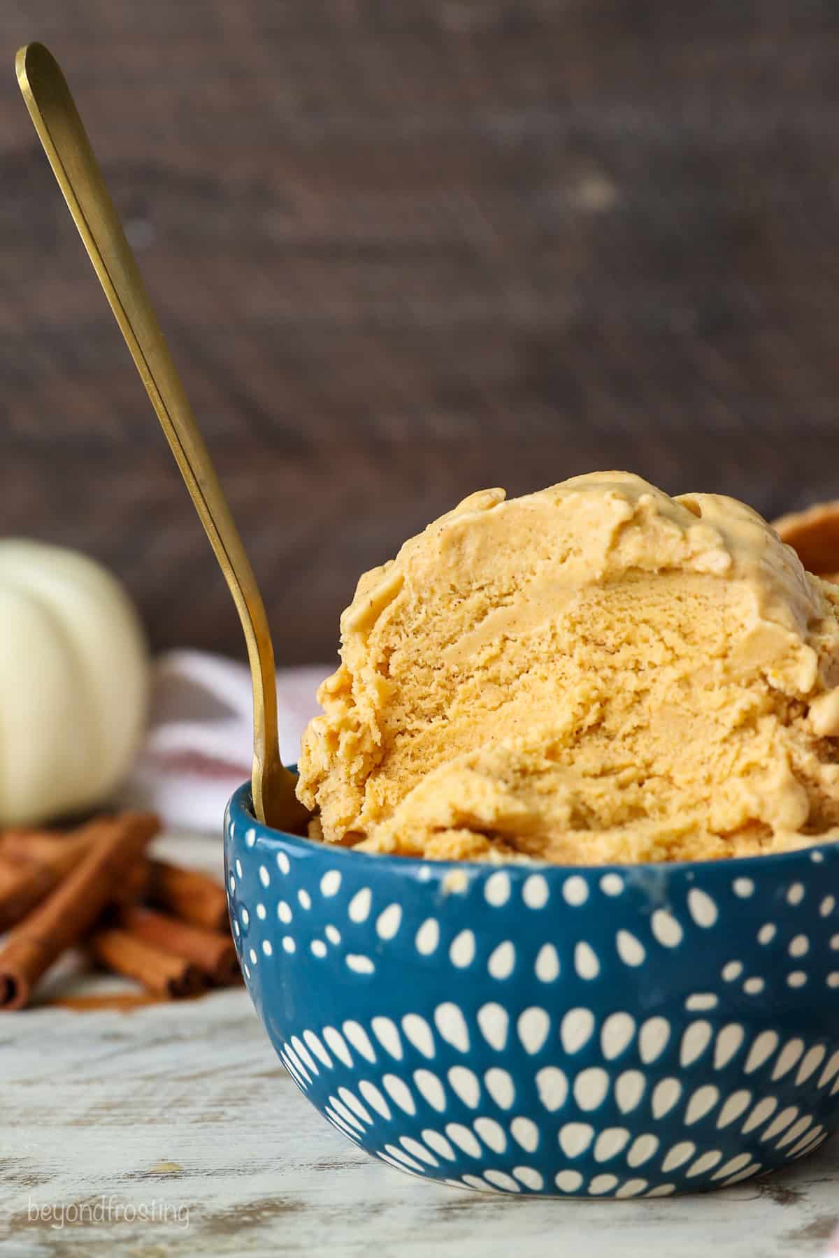 Side view of pumpkin pie ice cream in a blue and white patterned bowl with a spoonful missing.