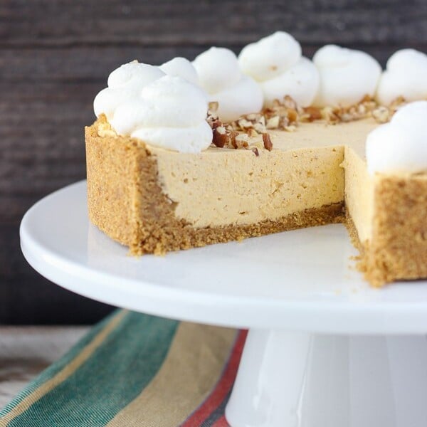 A sliced no-bake pumpkin cheesecake on a white cake plate