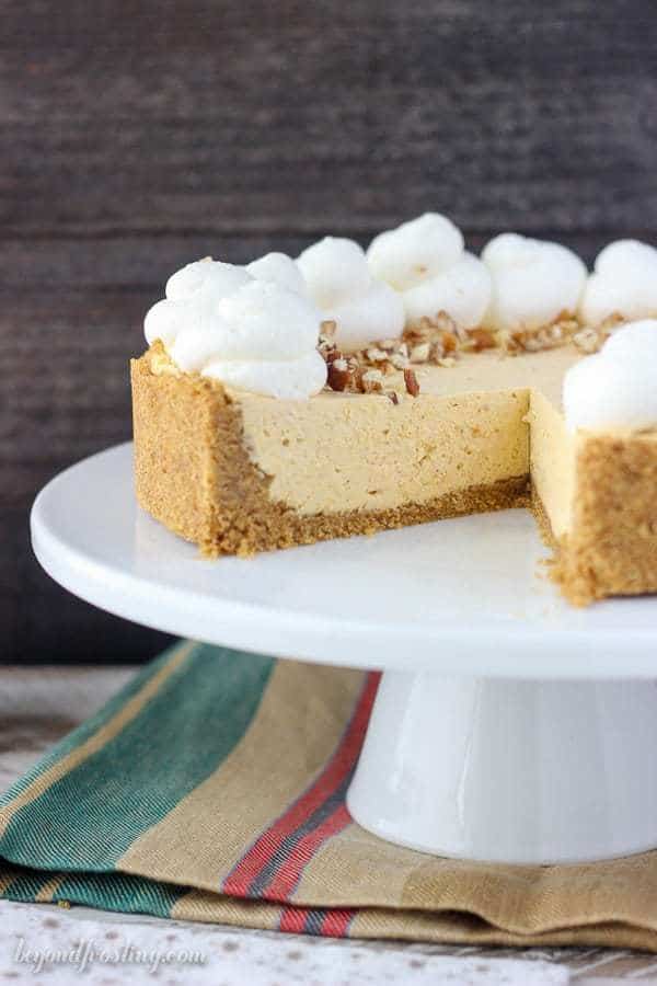 A sliced no-bake pumpkin cheesecake on a white cake plate