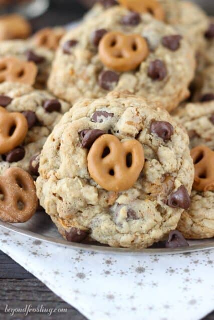 Salty oatmeal cookies with a ribbon of caramel, chopped pretzels, chocolate chips and a salted caramel coated pretzel on top.