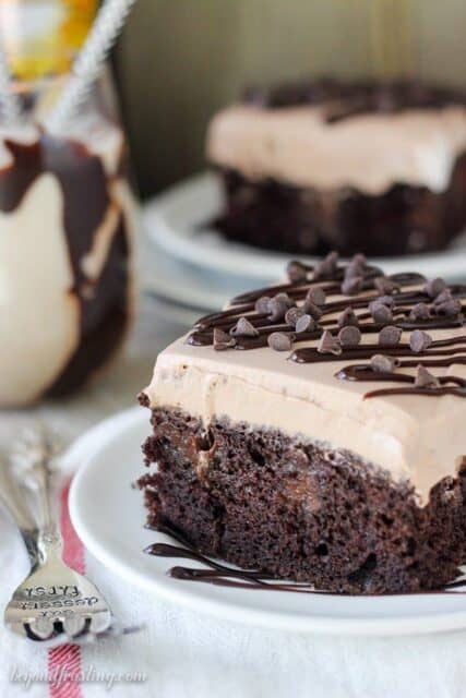 Questo Mudslide Poke torta è caricato con Bailey e Kahlua e un sacco di cioccolato. È una torta al cioccolato fondente imbevuta di una ganache al cioccolato a spillo, budino al cioccolato Kahlua e una mousse al cioccolato a spillo in cima.