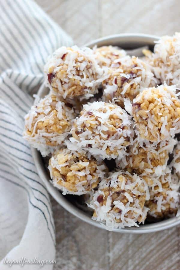 An overhead shot of a bunch of coconut balls sitting in a cake tray