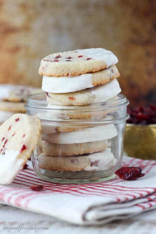 a small glass jar filled with white chocolate dipped shortbread cookies