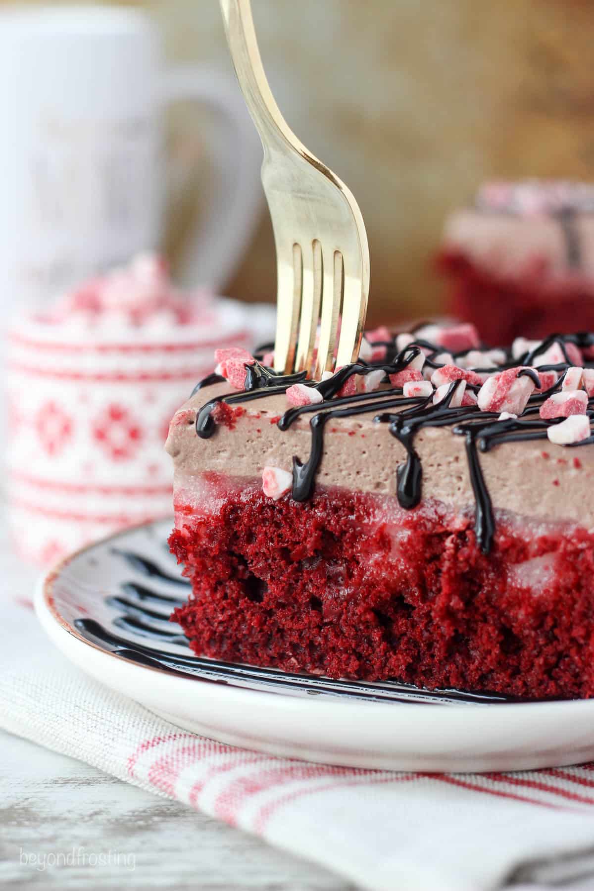 fork being put into a slice of peppermint hot chocolate poke cake