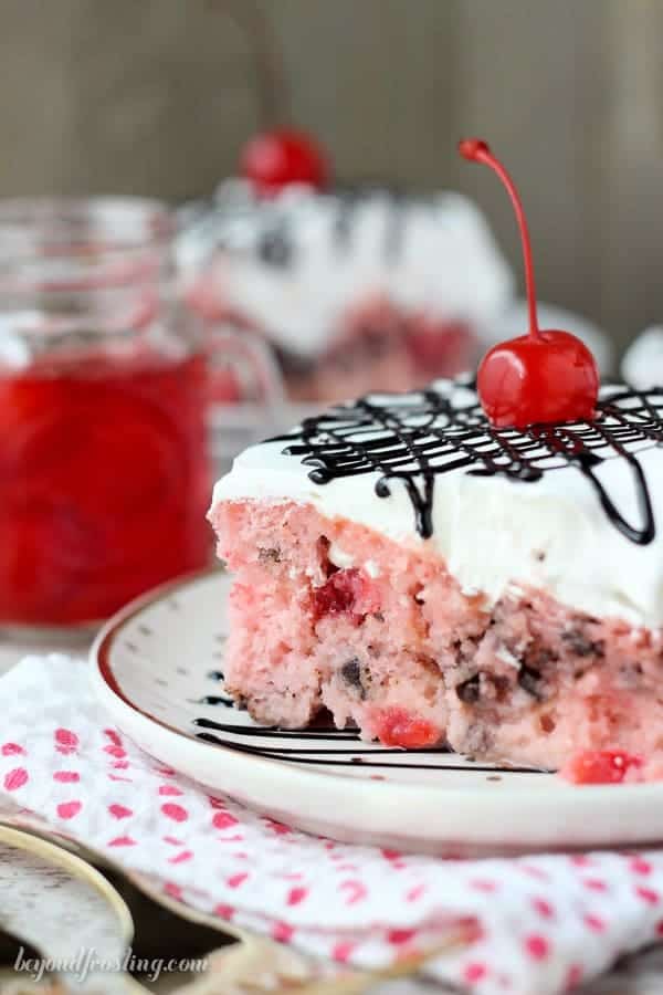 This Cherry Chocolate Chip Poke Cake is a sweet cherry cake with chocolate chips, soaked in sweetened condensed milk and topped with whipped cream and chocolate sauce.
