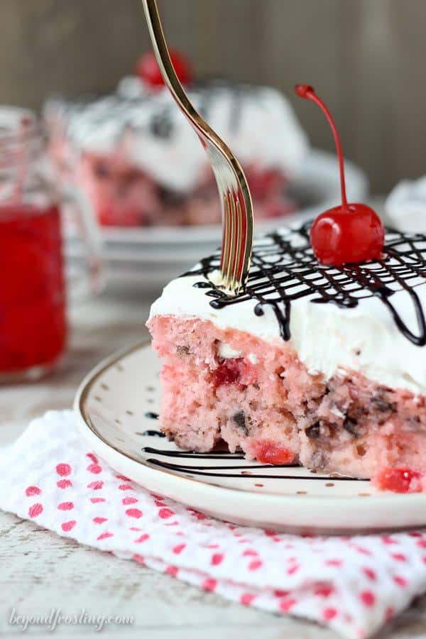 This sweet Cherry Chocolate Chip Poke Cake is a cherry cake filled with chocolate chips and sweetened condensed milk. It’s topped with whipped cream and chocolate sauce. This fun cake is perfect for Valentine’s day or any day of the year!