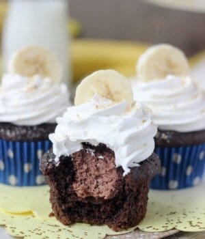 Three chocolate banana cream pie cupcakes: chocolate banana cupcakes filled with a chocolate mousse and topped with whipped cream, bananas and Nilla Wafers.