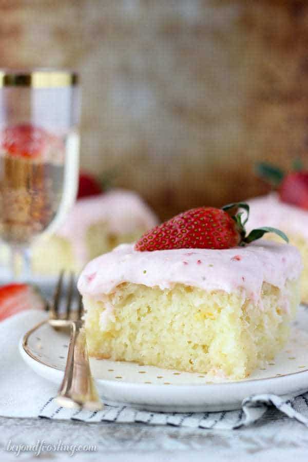 This Strawberry Champagne Cake is an orange infused vanilla cake soaked in a champagne glaze and topped with a tangy strawberry cream cheese frosting.
