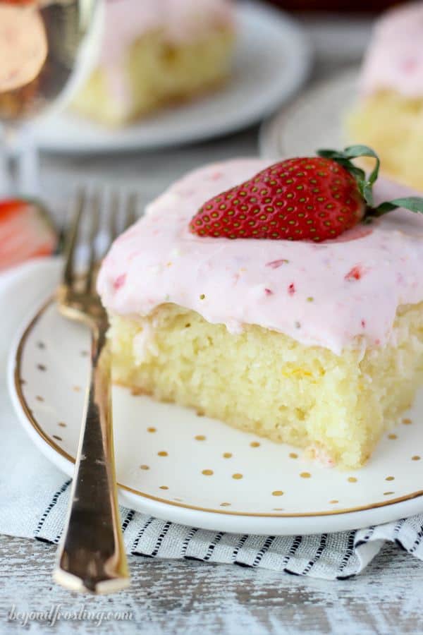 This Strawberry Champagne Cake is an orange infused vanilla cake soaked in a champagne glaze and topped with a tangy strawberry cream cheese frosting.