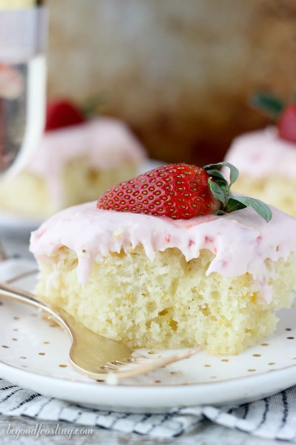 This Strawberry Champagne Cake is an orange infused vanilla cake soaked in a champagne glaze and topped with a tangy strawberry cream cheese frosting.