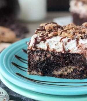 A Piece of Chocolate Chip Cookie Poke Cake on a Turquoise Plate