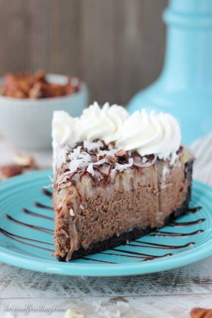 a side view of a slice of chocolate cheesecake layered with a sweet coconut topping