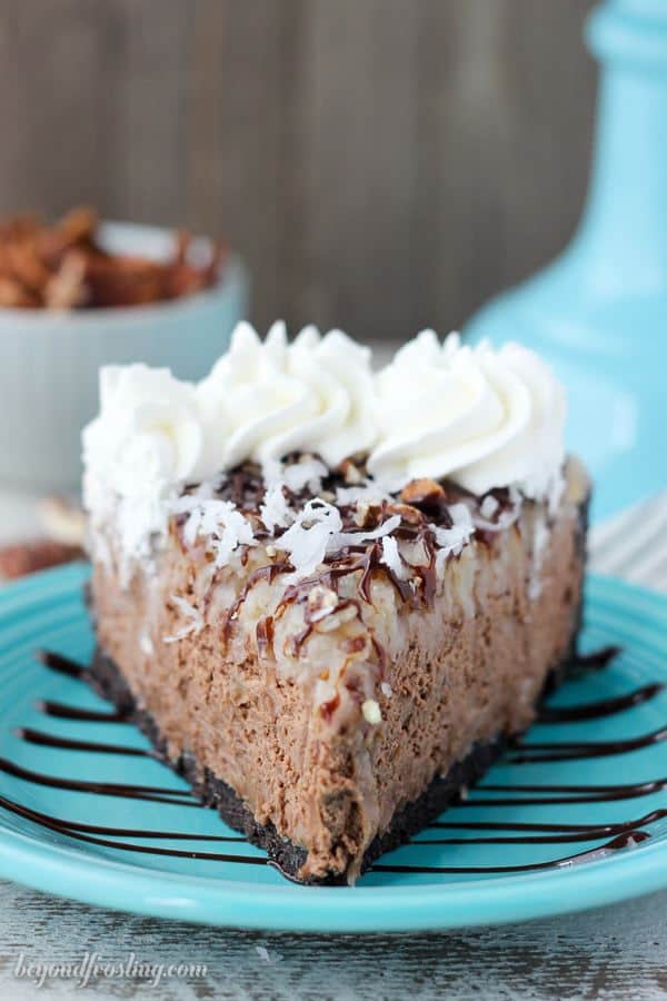 A slice of No-Bake German Chocolate Cheesecake on a teal plate