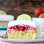 A slice of margarita lime cake topped with a strawberry cream and whipped cream