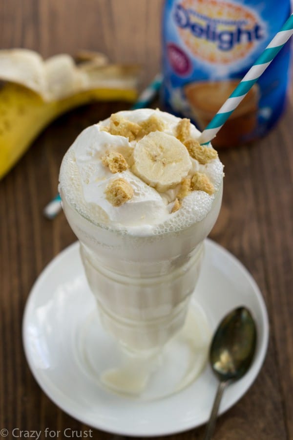 A Glass Filled with a Skinny Banana Cream Pie Milkshake and a Blue Striped Straw