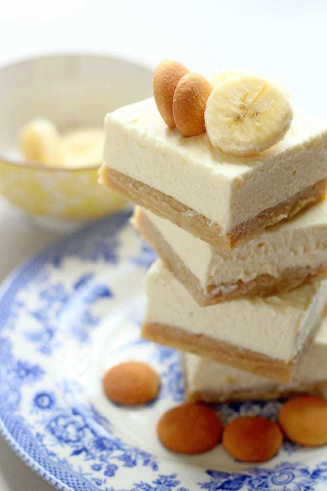 A Stack of Four Banana Pudding Cheesecake Blondies on a Plate with Four Vanilla Wafers