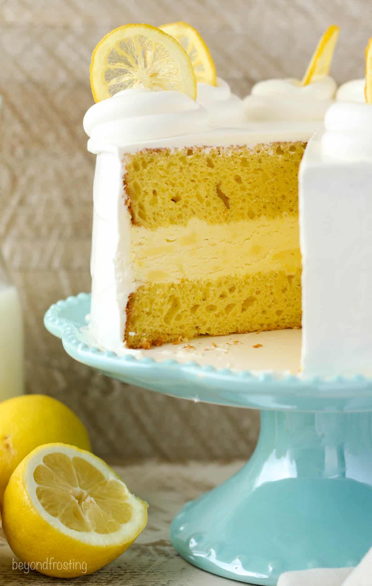 Lemon ice cream cake on a stand with one slice missing