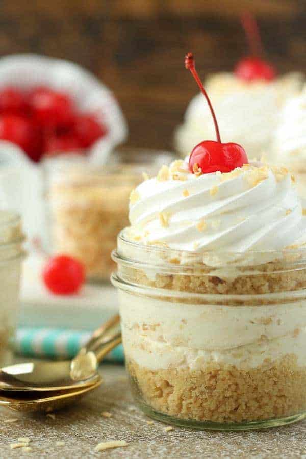 These No-Bake Piña Colada Cheesecake Parfaits are both refreshing and indulgent. These layered cheesecake parfaits start with a buttery Oreo cookie crust. The creamy pineapple coconut cheesecake filling has a hint of rum.